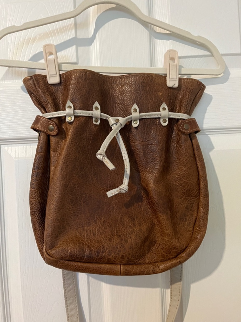 Custom cognac leather bucket bag with cream cross body strap
